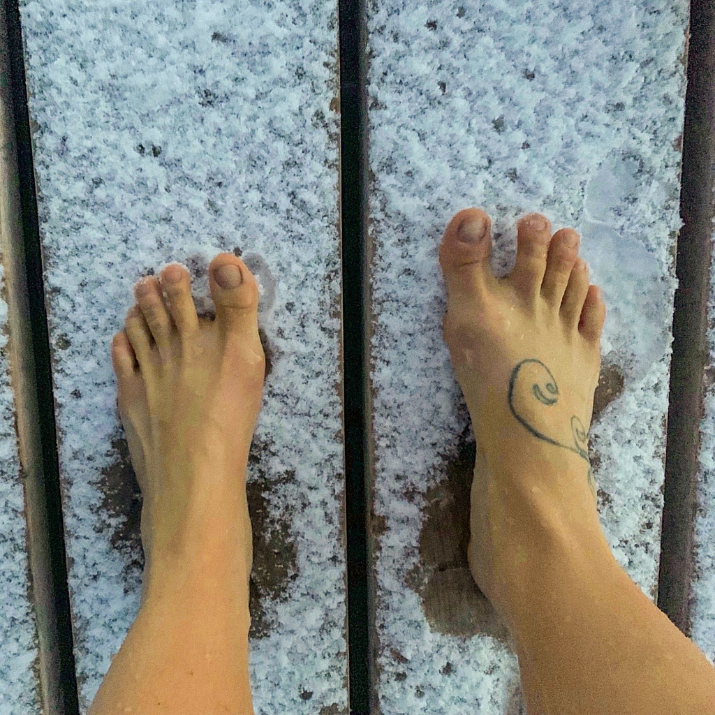 Bare feet in the snow showing the cold