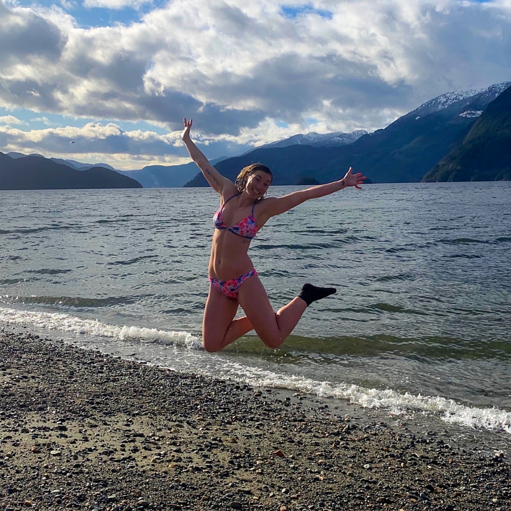 Girl jumping in front of the ocean